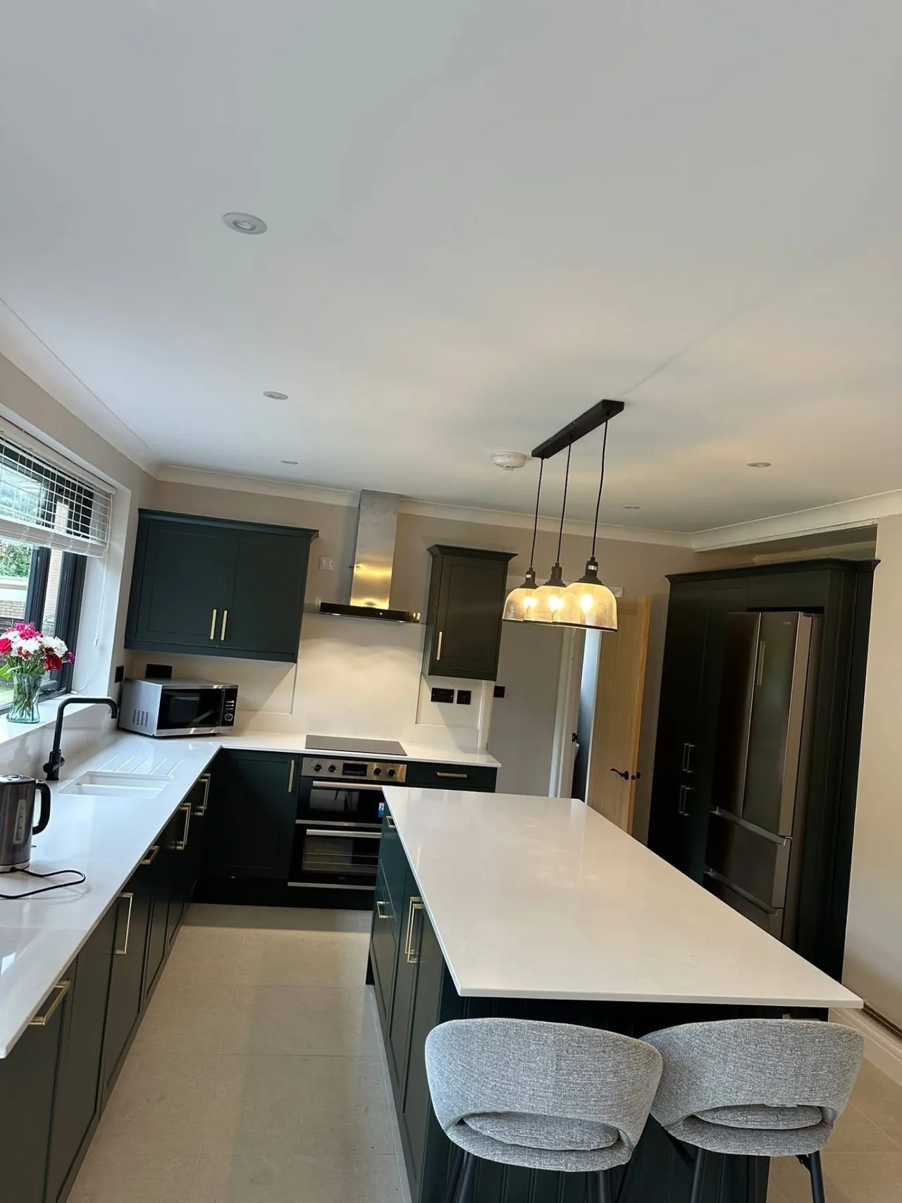 Kitchen lighting with pendant lights over an island and LED downlights