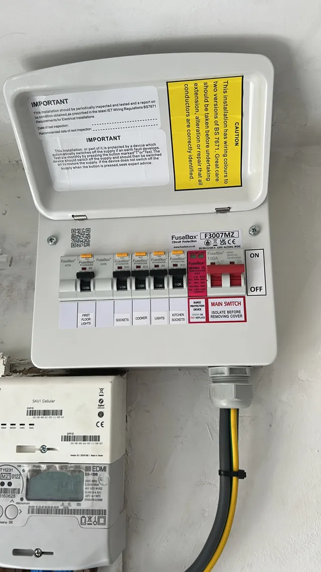 Modern consumer unit installed above the electricity meter with neat meter tails