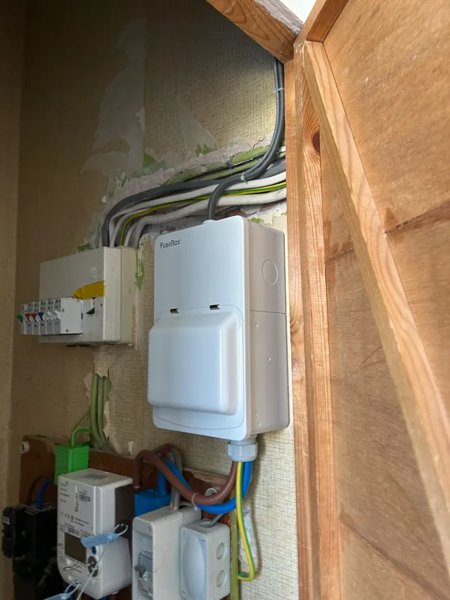 Electrician fault finding at a domestic electrical intake with consumer unit and isolator