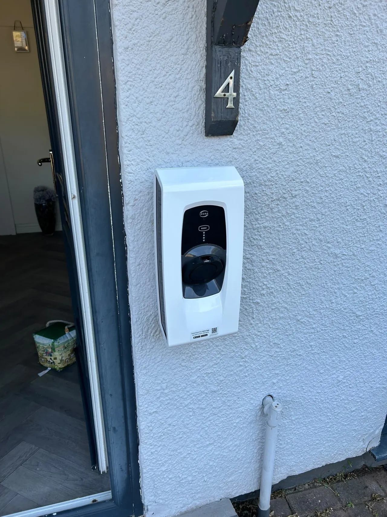 Domestic EV charger fitted beside a front door with protected cable route