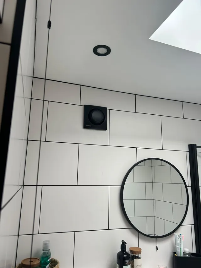 Bathroom extractor fan and LED downlights installed in a tiled bathroom